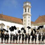 Studendi di Coimbra durante la foto di gruppo a fine carriera lanciano in aria i propri mantelli neri.