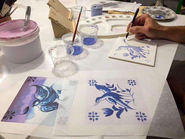 Un artista ricopia a mano su di un azulejos un precedente disegno realizzato come modello.